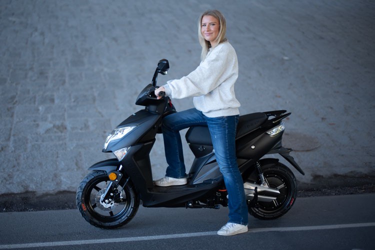 En kvinna på en moped